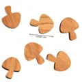 Close-up detail view of wooden mushroom shaped magnetic pieces showcasing fine grain and size. - Mushroom
