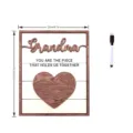 Detailed view of the wooden grandma plaque featuring heart puzzle design and accompanying marker. - Style A