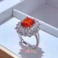 Primo piano dettagliato di un elegante anello con pietra rossa e zirconi brillanti. - Anello / Rosso