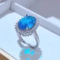Elegante anello da donna in argento con gemma blu ovale e corona di zirconi luminosi. - Solo Anello / Blu