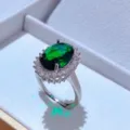 Primo piano dettagliato di un elegante anello con gemma verde ovale e zirconi scintillanti. - Solo Anello / Verde