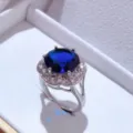 Dettaglio ravvicinato di elegante anello in argento con gemma blu centrale e contorno di zirconi. - Anello / Blu