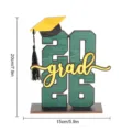 Dettaglio decorazione da tavola per festa di laurea 2026 in legno con altezza 20 cm. - BT362: modello E verde (su pannello KT)