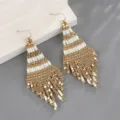 Κοντινό πλάνο σε boho χρυσά και λευκά σκουλαρίκια με χάντρες, χειροποίητο σχέδιο. - Λευκό
