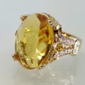 Detailaufnahme eines luxuriösen 18k vergoldeten Rings mit ovalem gelben Edelstein und Zirkonsteinen - Größe 6 / Champagner