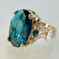 Detailansicht eines luxuriösen 18k vergoldeten blauen Edelsteinrings mit Zirkonia-Besatz. - Größe 9 / Pfauenblau