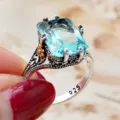 Close-up detail of vintage Thai silver blue topaz ring with intricate flower carving. - Size 6 / Antique Silver Sea Blue