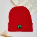 Red knitted beanie hat with cute green frog embroidery, warm winter pull-on ski cap for daily wear. - Red