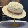 Detail view of the beige hollow flat top straw hat with brown belt and chic metallic accent. - Beige Hollow Straw Hat with Belt