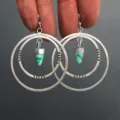 Detailfoto van retro dubbele creolen oorbellen met turquoise steen hanger aan een zilveren haak. - Dubbellaagse Cirkelhanger Stijl (HE-11481)