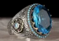 Primo piano dettagliato di anello uomo vintage in argento con gemma blu e decoro. - Taglia 8 / Argento Antico Blu Acquamarina