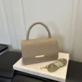 Sac bandoulière minimaliste chic kaki avec poignée structurée et bandoulière élégante. - Kaki