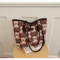 Vue détaillée de ce sac cabas en toile avec motif d'ours marron et poignées en cuir. - Sans pendentif / Marron