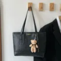 Elegante borsa tote nera in pelle intrecciata con ciondolo orsetto, pratica borsa a spalla - Con ciondolo / Nero
