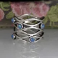 Close-up detail of vintage silver openwork interlocking ring with sparkling blue opal stones. - Size 6 / Antique Silver Blue Opal