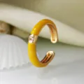 Primo piano dettagliato dell'anello aperto minimalista in smalto giallo con zircone. - Aperto Regolabile / Giallo Zenzero