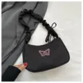Vista dettagliata della borsa a spalla in nylon nero con ricamo farfalla rosa e manico arricciato. - senza ciondolo / Nero