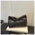 Dark grey leather clutch bag with elegant bow design, stylish and minimalist daily accessory. - Black