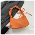 Vista dettagliata della borsa in nylon arancione con ricamo farfalla rosa e manico arricciato. - senza ciondolo / Arancione