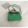 Green ostrich pattern Kelly bag detail, elegant top handle handbag with chic scarf accent. - Green