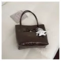 Détail de sac cabas en cuir synthétique marron foncé avec nœud et pendentif étoile. - Avec Pendentif / Café