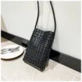 Vue detaillee elegante du sac bandouliere telephone tisse noir pour femme mode ete. - Noir