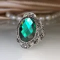 Detailweergave van de vintage groene edelsteenring met fijne metaalsnijwerk en kristalfacetten. - Maat 6 / Zirconia Ingelegd / Smaragd