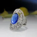 Gedetailleerde close-up met de prachtige blauwe kristalen en strass ringvormgeving. - Maat 6 / Blauwe strass