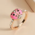 Nahaufnahme des rosévergoldeten Marienkäfer-Rings mit rosa Emaillierung und funkelnden Strasssteinen. - Größe 6 / Rosa