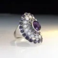Gedetailleerde close-up van een opvallende cocktailring met paarse stenen en opalen. - Maat 7 / Fuchsia