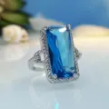Close-up detail of a stunning rectangular blue crystal ring with sparkling pave zirconia halo. - Size 6 / Navy Blue