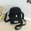 Schwarze Mini Umhängetasche für Damen, stilvolle Outdoor Schultertasche mit Label und Kordel. - Schwarz