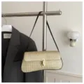 Chic woven straw shoulder bag with gold tone lock clasp and sleek strap for women. - Black