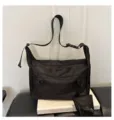 Detail of black nylon crossbody bag featuring front zipper pockets and convenient small pouch. - Black