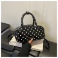 Stylish black and white polka dot handbag with top handle and shoulder strap for women daily use. - Black