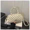White and black polka dot cosmetic bag with handle and shoulder strap for women daily use. - White