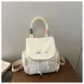 Casual canvas backpack for women, stylish daily commuter school bag with cute embroidered details. - White