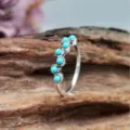Close-up van de zilveren boho ring met turquoisekleurige kralen op een golvende band. - Maat 6 / Antiek Zilver