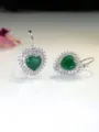 Dettaglio ravvicinato di orecchini con zircone a cuore verde, alone luminoso e ganci argentati. - Cuore Verde