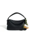 Chic borsa a tracolla nera in pelle con manico intrecciato e ciondolo floreale. - Nero