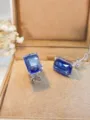 Primo piano di eleganti orecchini in argento con pietre blu rettangolari, dettagli raffinati. - pietra blu / Argento