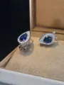 Primo piano dettagliato di eleganti orecchini a forma di pera con zirconi blu brillanti. - Intarsio in Zirconia a Goccia / Bianco K Blu