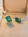 Dettaglio in primo piano di lussuosi orecchini quadrati con gemma verde in argento. - Pietra verde / Argento