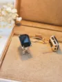 Primo piano dettagliato di orecchini con pietra nera rettangolare in una elegante scatola. - pietra preziosa nera / Oro