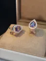 Dettaglio in primo piano di lussuosi orecchini a goccia viola con alone di zirconi. - Intarsio in Zirconia a Goccia / Tono Oro / Viola