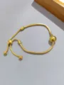 Dettaglio del bracciale a catena di serpente dorato con perle regolabili per stile chic. - Stile Sfera Metallica Liscia / Sfera Lucida Dorata