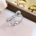 Gros plan d'une bague nœud argentée étincelante sertie de zircons cubiques brillants. - Taille unique / Argent Avec Zirconia Blanc