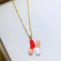 Primo piano di collana catena oro con ciondolo lettera N smaltato colorato, design fine. - Lettera N