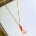 Primo piano dettagliato della collana con ciondolo lettera W capsula colorata su catena. - Lettera W
