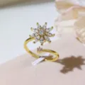 Primo piano dettagliato di un anello aperto dorato con motivo floreale in zircone cubico. - Fiore d'oro